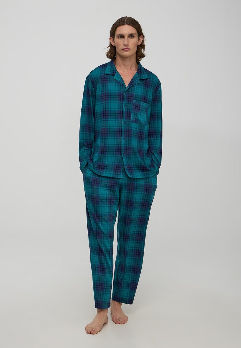 Pajama set w kratkę w kolorze turkusowym, granatowym i czarnym. Koszula z guzikami i kieszonką. Luźne spodnie z elastycznym pasem. Miękka tekstura materiału.