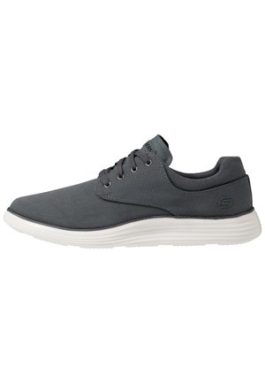 Ciemnoszary sneaker na sznurowadła z białą podeszwą, cholewką z siateczkowego materiału i zaokrąglonym noskiem, widziany z boku.