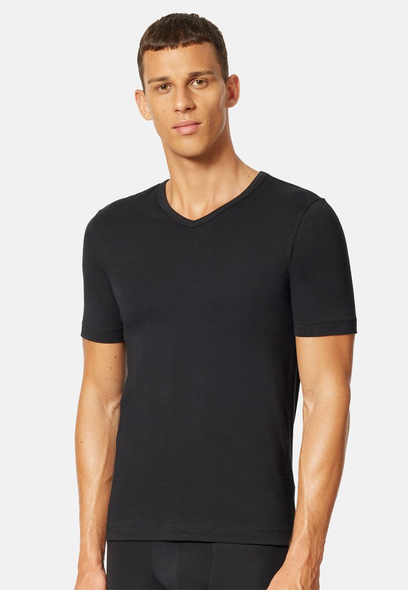 Sort kortærmet V-hals t-shirt lavet af glat bomuld, med et tætsiddende design og diskret syning langs halsudskæringen.