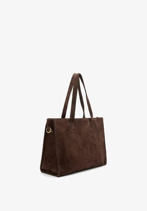 Rechthoekige donkerbruine suède shoppers met gestikte randen, dubbele handvatten en een gouden ringdetail aan de zijkant.