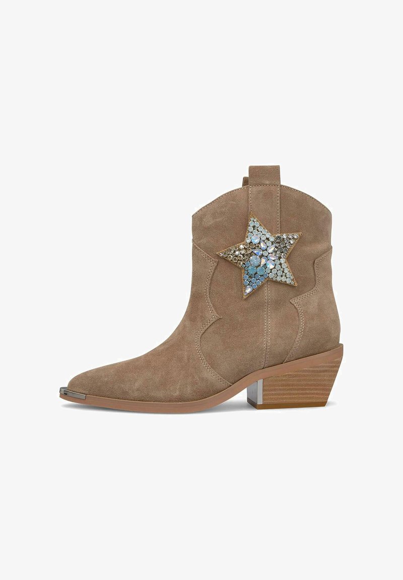 Botín de ante beige hasta el tobillo con bajo tacón de madera apilada, punta afilada y un gran aplique en forma de estrella decorativa con cristales azules y transparentes.