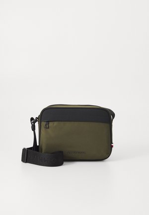 Khaki crossbody taske med sort topsektion, udstyret med justerbar rem, lynlåslukning og præget logo på fronten. Glat, slidstærkt materiale.