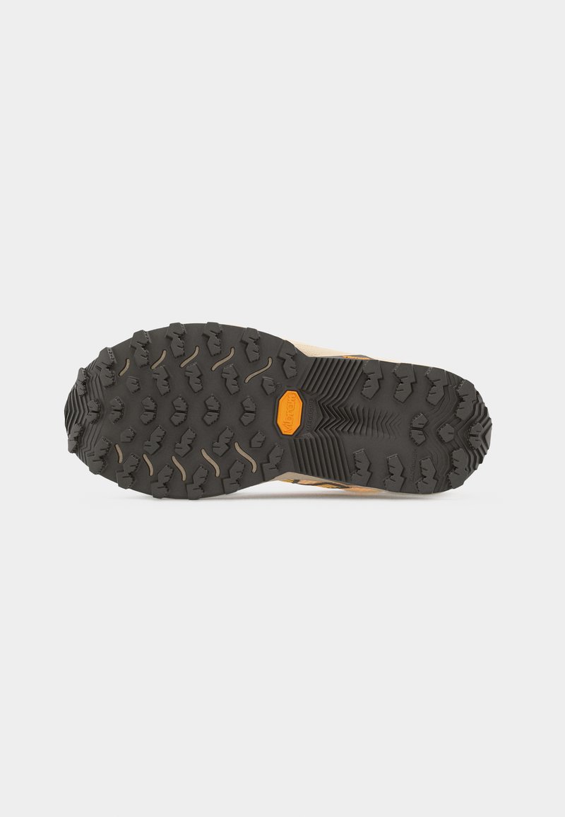 Suela Vibram negra y resistente de una bota de senderismo beige con patrones de banda de rodadura profunda para un mejor agarre sobre un fondo blanco.