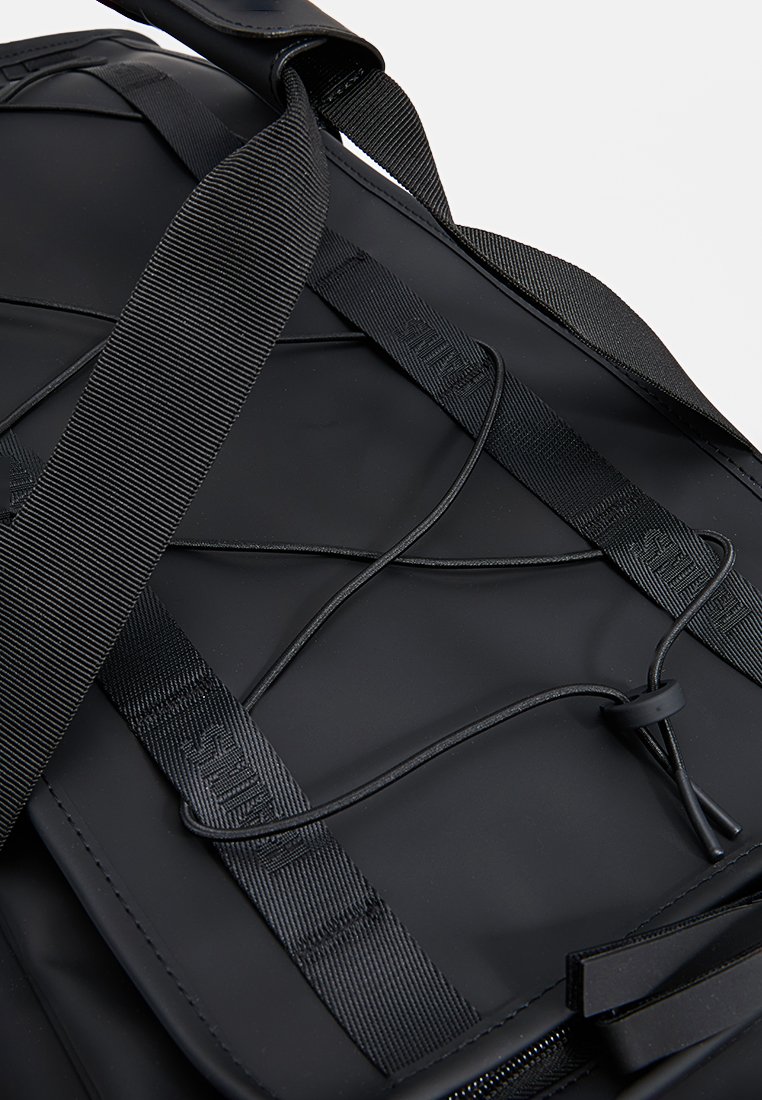 Sac à dos noir avec une surface lisse, des bretelles ajustables et un détail de laçage à l'avant. Il dispose d'une fermeture éclair et de quincaillerie robuste.