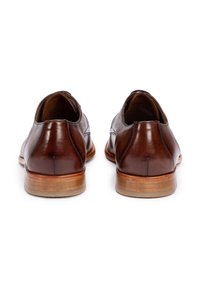 Braune Leder Schuhe mit glatter Oberfläche, runder Spitze und niedrigem Holzabsatz. Mit einer Nahtverarbeitung an den Seiten und hinten.