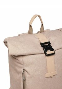 Beige fabric backpack with a roll-top design, featuring a black buckle closure and a side zipper. Textured material and reinforced handle.