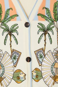 Light cream cardigan with blue accents. Features tropical palm tree and fish embroidery, button closure, and detailed decorative elements.