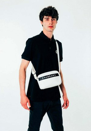 Sac bandoulière blanc de forme rectangulaire, avec une sangle noire et le mot "CHABRAND" en lettres majuscules en gras sur le devant.