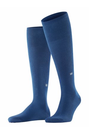 Chaussettes montantes de couleur bleu marine unie, avec un bord ribbé en haut et une texture lisse. Comprend un petit logo blanc sur le côté.