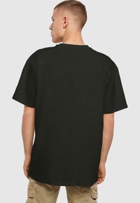 Sort bomulds T-shirt med korte ærmer, rund halsudskæring og afslappet pasform. Stoffet ser glat ud uden synlige mønstre eller detaljer.
