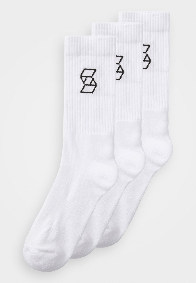 Fehér pamut crew zoknik bordázott mintázattal és fekete geometriai logóval az elülső részen. Három párból álló szett.
