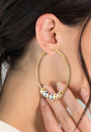 Boucle d'oreille en or avec un cluster de perles multicolores—blanches, argentées et or rose—près du bas. Texture lisse, design circulaire.