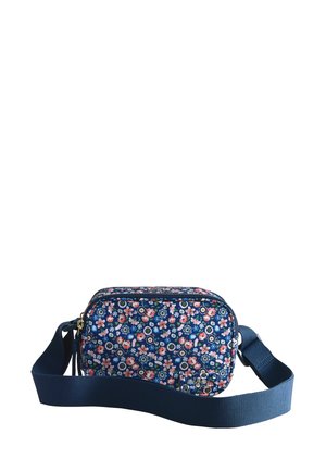 Sac bandoulière bleu marine avec sangle réglable, décoré de petits motifs floraux roses, blancs et verts, avec une fermeture éclair à l'avant.