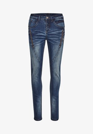 Ahnedus, tumedates sinimuitudes, millel on ees lukkudega taskud, kerge pleekimine ja kontrastsed õmblused. Keskmise kõrgusega vöökoht.