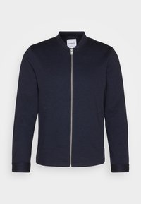 Námořnická modrá mikina na zip vyrobená z měkké tkaniny, s kulatým výstřihem, zipovým uzávěrem a pružnými manžetami. Minimalistický design bez vzorů.