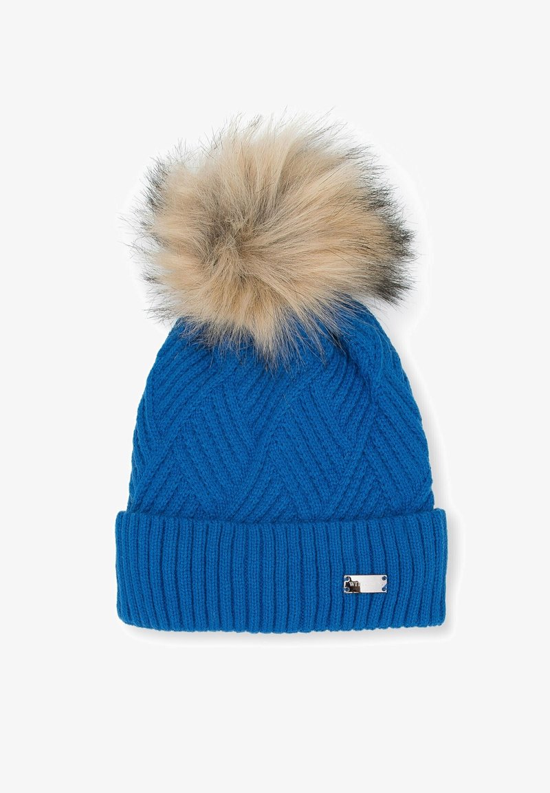 Bonnet d'hiver en tricot bleu avec bord côtelé et gros pompon en fausse fourrure beige et marron sur le dessus, sur fond blanc.