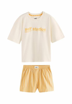 Person wearing light yellow striped shorts with a white waistband labeled "self." and lifting a white shirt slightly.