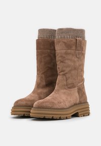 Bottines en daim marron avec un revers en tricot texturé et une semelle en caoutchouc épaisse. Elles présentent un panneau latéral et des détails de couture.