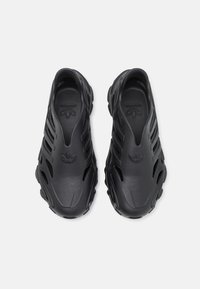 Svarta slip-on skor gjorda av släta syntetmaterial, med en texturerad yta, ventilationshål och en präglad logotyp på innersulan.