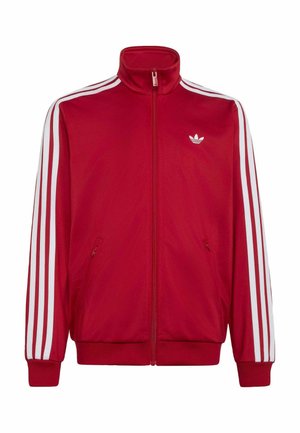 Červená sportovní bunda na zip s bílými třemi pruhy na rukávech a malým bílým logem Adidas na levé straně hrudi.