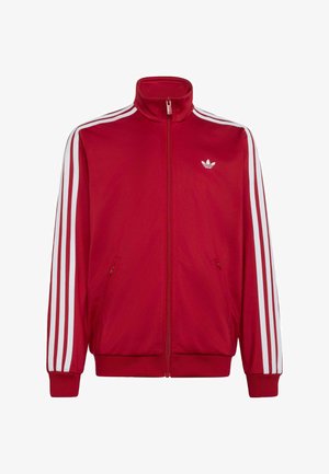 Červená sportovní bunda na zip s bílými třemi pruhy na rukávech a malým bílým logem Adidas na levé straně hrudi.
