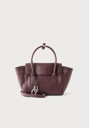 Sac à main en cuir violet foncé avec des poignées courtes, un rabat avant, des anneaux argentés et une bandoulière réglable sur fond blanc.