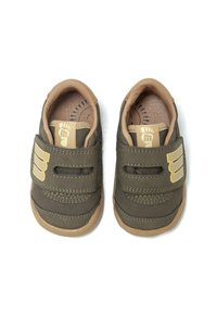 Chaussures en tissu vert avec un intérieur beige et une semelle en caoutchouc. Deux bandes Velcro et un accent de logo sur le côté. Design à bout rond.