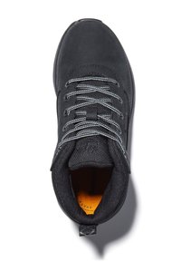 Chaussure de sport noire avec une tige en daim et en mesh, lacets gris, col rembourré et semelle en caoutchouc avec une finition texturée.