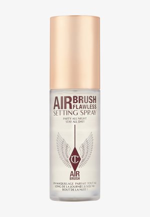 Clear setting spray in a transparent bottle with a gold cap. Features "Airbrush Flawless" text and winged logo. 150ml capacity.