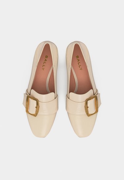 Paire de mocassins en cuir beige avec boucles dorées et bouts carrés, intérieur marqué de la marque Bally, vus de dessus sur fond blanc.