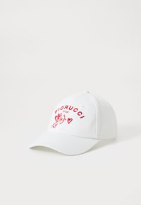 Bela bejzball kapa z rdečim vezenim napisom "FIORUCCI" in grafiko cheruba, s ukrivljenim robom in nastavljivim trakom.