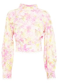 Blouse courte en tissu léger avec un motif floral rose sur fond crème. Comprend des manches longues et un ourlet festonné.