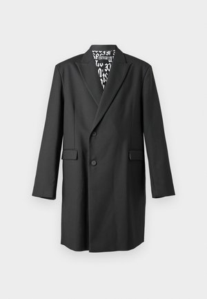 Black tailored coat with a double-breasted design, notched lapels, and two front pockets. Lined interior features a contrasting graphic pattern.
