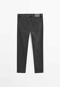 Czarne dżinsy o slim fit. Posiadają dwie tylne kieszenie, przeszycia oraz metkę markową na pasku. Matowa faktura, brak wzorów.