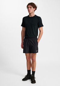Schwarzes Sport-T-Shirt und schwarze Shorts mit rundem Halsausschnitt, kurzen Ärmeln, elastischem Bund und kontrastierendem Logodetail.