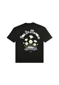 Zwart T-shirt met witte bloemen die uit een vintage auto groeien en de tekst „Pas De Monaco“ gebogen erboven in witte letters.