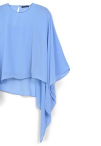 Top in chiffon blu chiaro con un design morbido, maniche ampie e scollatura rotonda. L'orlo presenta un Taglio asimmetrico.