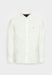 Hellgrünes Hemd mit kleinen Punkten, langen Ärmeln und spitzem Kragen. Mit Markenlogo auf der linken Brust.