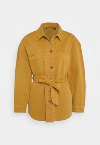 Hořčicově žlutá džínová bunda s dlouhými rukávy, dvěma kapsami na prsou, předním zapínáním na knoflíky a opaskem s uvázáním v pase. Texturovaný povrch.