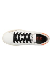Sneaker bianco con lacci neri, dettagli beige e una parte posteriore arancione. Presenta un materiale in pelle liscia e una suola in gomma piatta.