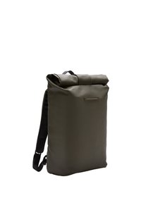 Sac à dos vert à rabat fabriqué en matériau lisse, doté de sangles noires réglables, d'un accent minimaliste en métal argenté et d'une forme rectangulaire élégante.