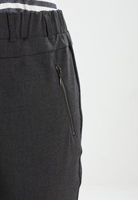 Gray pants with a stretchy waistband, featuring a side zippered pocket and a smooth, slightly textured fabric.