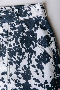 Τζιν παντελόνια με λευκή βάση και αφηρημένο σχέδιο πιτσιλιών σε ναυτικό μπλε. Διαθέτουν μπροστινή τσέπη, εμφανείς ραφές και θηλιές για ζώνη.