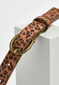 Leder-Gürtel mit Leopardenmuster, der eine strukturierte Oberfläche, braune und schwarze Muster sowie eine runde Messing-Schnalle mit einem Dorn aufweist.