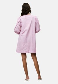 Rosa Leinenkleid mit puffartigen langen Ärmeln, lockerer Passform und knielangem Design. Die Textur wirkt leicht zerknittert.