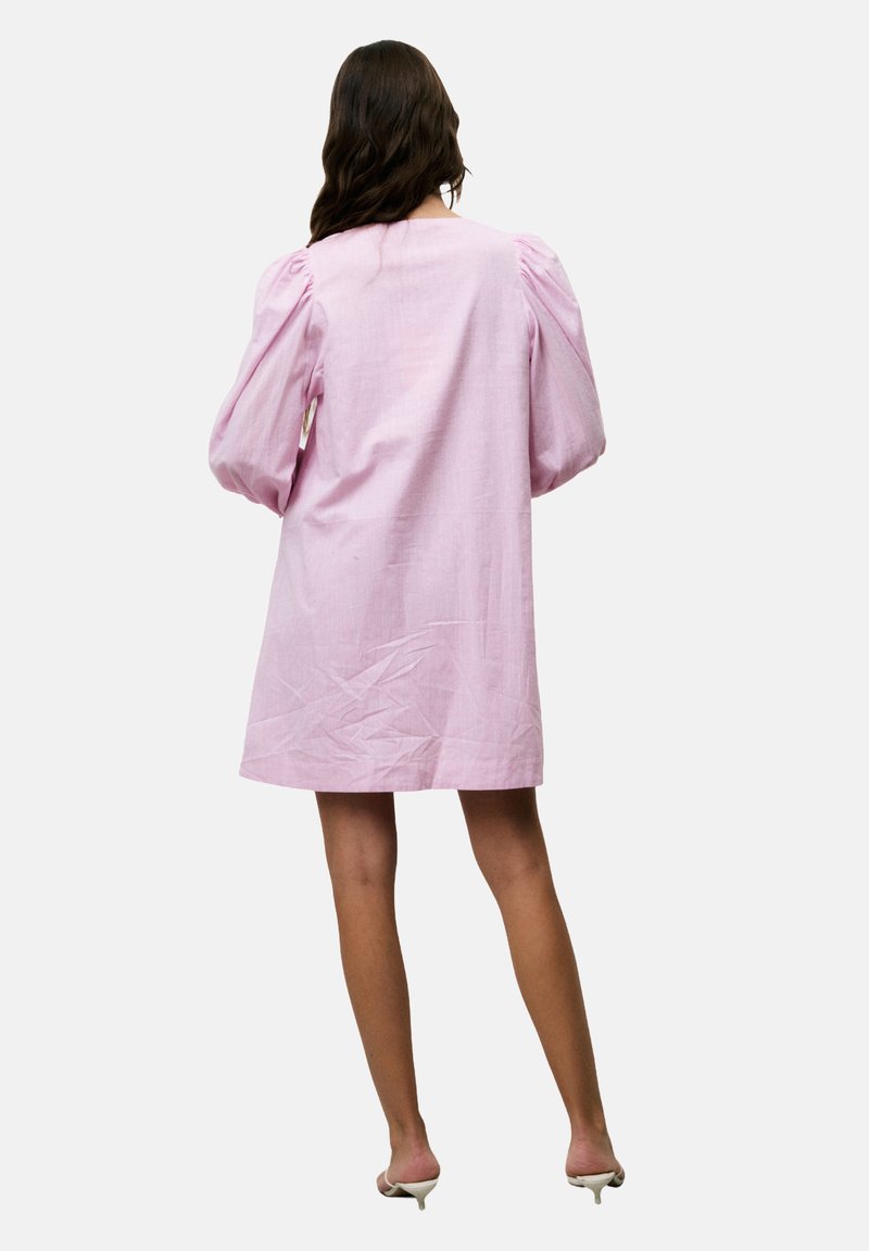 Rosa Leinenkleid mit puffartigen langen Ärmeln, lockerer Passform und knielangem Design. Die Textur wirkt leicht zerknittert.