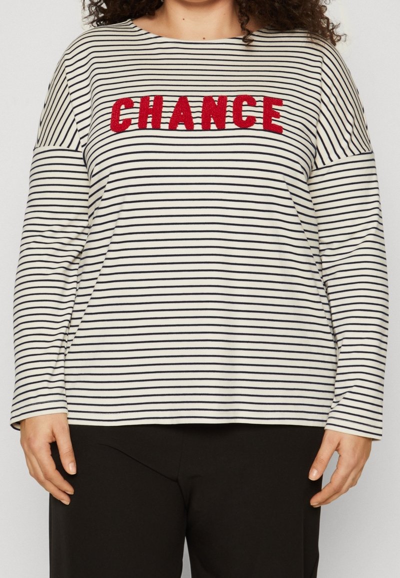 Striped long-sleeve top in cream and navy, featuring a bold red "CHANCE" embroidery across the chest. Soft fabric, relaxed fit.