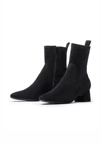 Bottines en suede noir avec un bout pointu, fermeture éclair sur un côté et un talon bloc. Texture lisse et design sans couture.