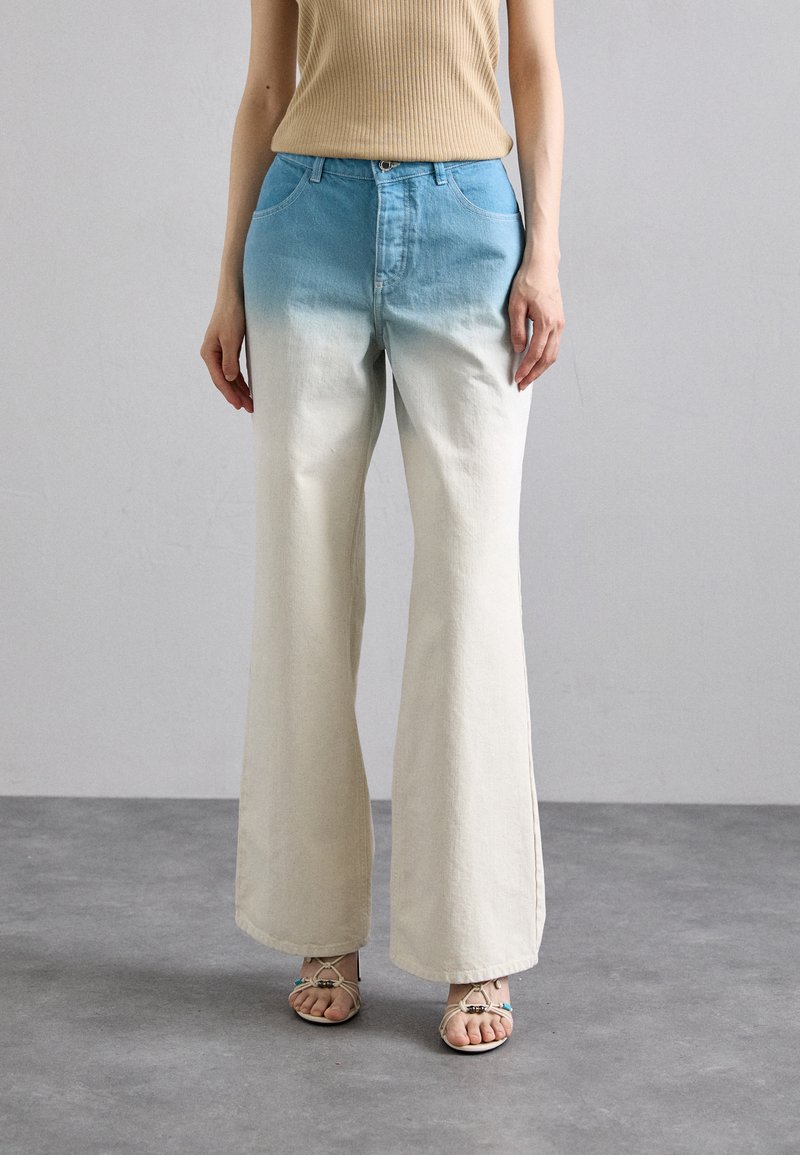 Pantaloni din denim cu picior larg, având un design ombre cu albastru deschis în partea de sus care se estompează spre alb murdar în partea de jos, punând în evidență un croi lejer și linii curate.