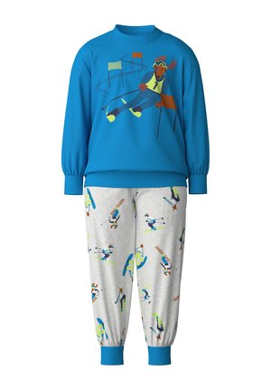 Blaues Sweatshirt mit einem Skifahrer-Grafik und grauen Hosen mit einem Skimuster. Beide aus weichem Stoff, mit Bündchen aus Rippstrick.